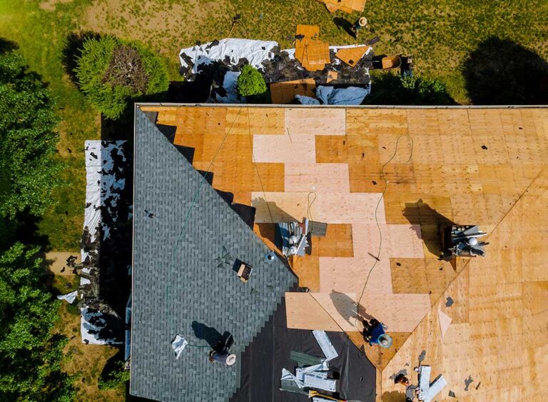 Homeowner photographing missing shingles and ceiling water stains after a storm.